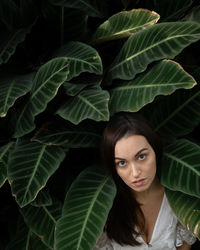 Portrait of young woman with green leaves