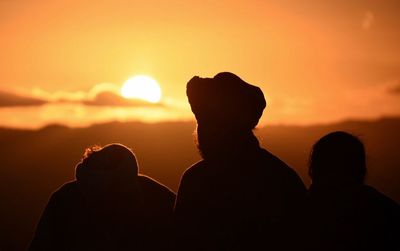 Silhouette people against sky during sunset