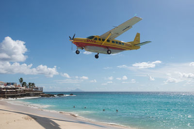 Airplane flying over sea against sky