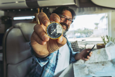 Close-up of man holding navigational compass