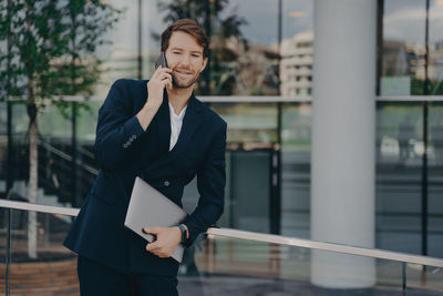 Mid adult man using mobile phone outdoors