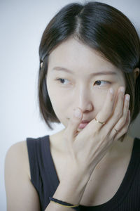 Close-up of young woman against white background