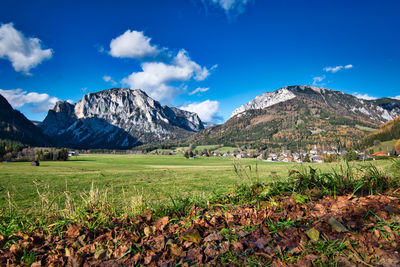 Scenic view of field and mountains against blue sky