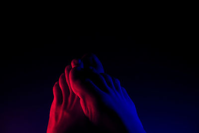 Close-up of human hand against black background