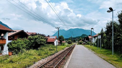 Railroad tracks by trees against sky