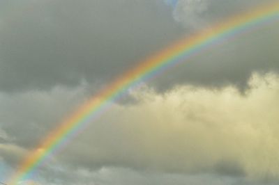 Low angle view of rainbow against cloudy sky