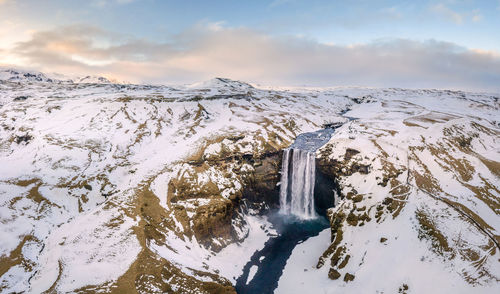 Scenic view of snow covered land against sky