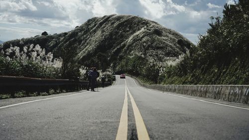 Rear view of man walking on road