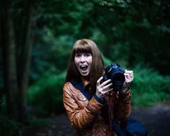 Portrait of smiling young woman in forest