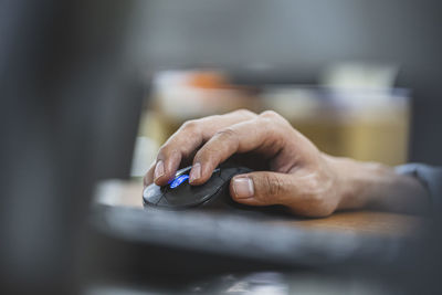 Close-up of person using mobile phone on table