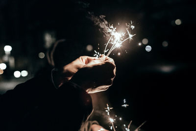 Close-up of man holding sparklers
