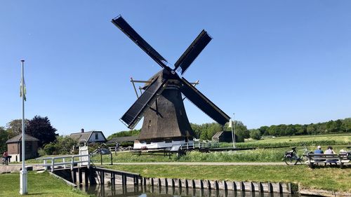 Traditional windmill on field against clear sky