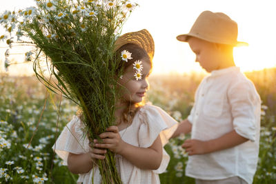 Girl holding camomile flowers on sunny day