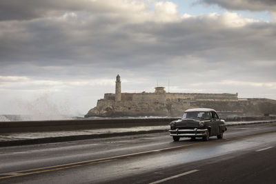 Car on road against cloudy sky