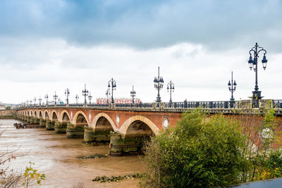 Pont de pierre over garonne river against sky in city