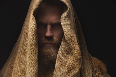 Close-up portrait of young man against black background