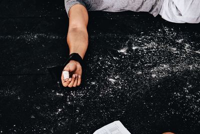 Midsection of man by powder lying down on floor