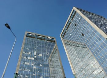 Low angle view of modern building against clear blue sky