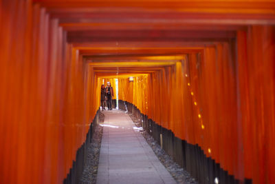 Rear view of people walking in corridor of building