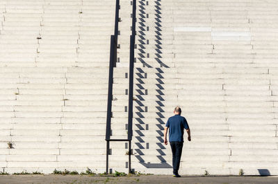 Rear view of man climbing steps