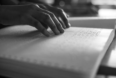 Cropped image of person reading braille