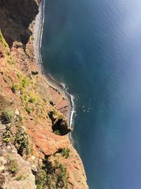 Aerial view of cliff by sea during sunny day