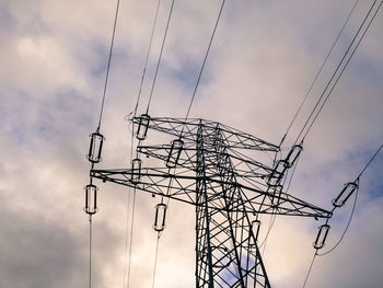 Low angle view of electricity pylon against sky