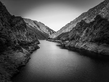 Scenic view of river amidst mountains against clear sky