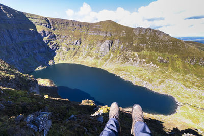 Low section of person on mountain by lake