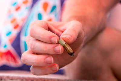 Close-up of hand holding cigarette