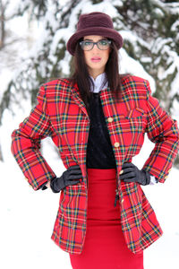 Portrait of smiling young woman standing on land during winter