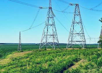 Electricity pylon on field against clear sky