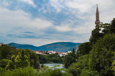 Panoramic view of trees and buildings against sky