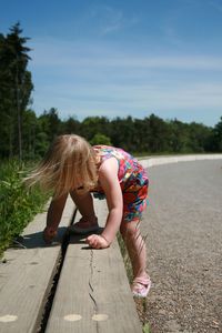 Rear view of girl climbing against sky