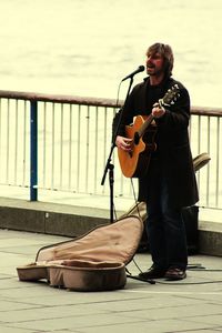 Full length of young man playing guitar