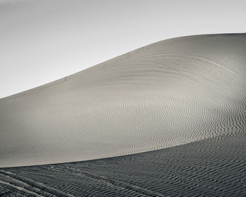 View of sand dunes against clear sky
