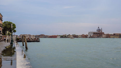 View of buildings in sea against cloudy sky