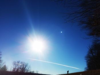 Low angle view of sun shining in sky