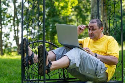 Man using laptop while sitting on field