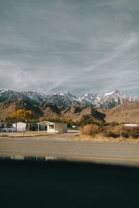 Road leading towards mountains against sky