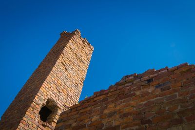 Low angle view of old building against blue sky