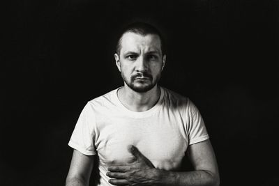 Portrait of man against black background