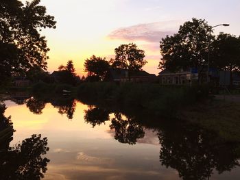 Reflection of trees in water at sunset