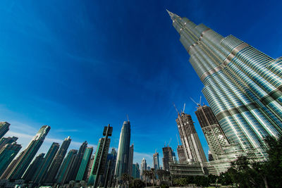 Low angle view of skyscrapers against blue sky