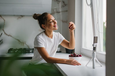 Young woman nutritionist blogger conducts a consultation or an open lesson by video link telling