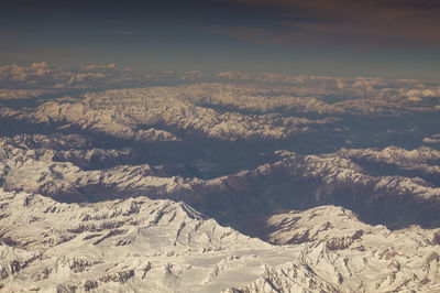 Snow-capped peaks and valleys of the alps seen from the plane