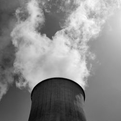 Low angle view of smoke emitting from chimney against sky