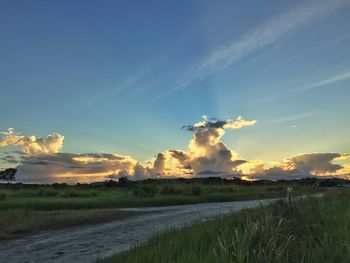 Scenic view of field against cloudy sky