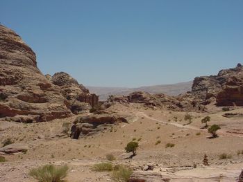 Rocks on desert landscape against clear sky
