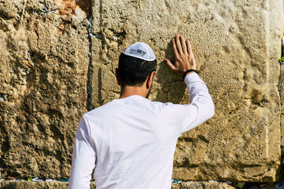 Rear view of man standing against wall